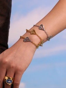 Bracciali a cuore in acciaio lucido e anello d'oro con occhio in smalto blu