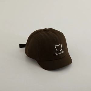 Vue détaillée d'une casquette bébé marron avec broderie d'ours et texte shuaikuku brodé