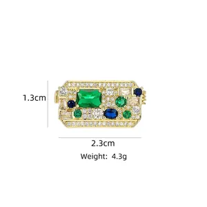 Detail view of gold geometric brooch with emerald-cut green stone and zircon dimensions