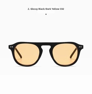 Detail of retro full frame sunglasses featuring orange lenses and metal rivets