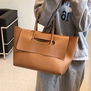 Brown leather large tote bag for women shown as a stylish shoulder bag on model