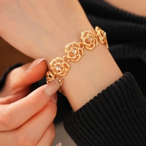 Macro shot of an elegant gold flower bracelet with crystal accents on a woman's wrist