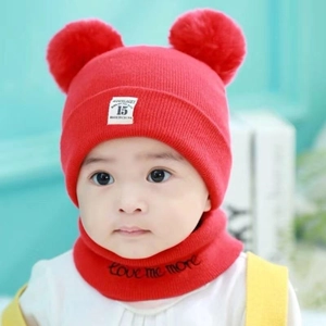 Detail of red baby knit beanie and scarf set with two pom-poms and Love Me More embroidery