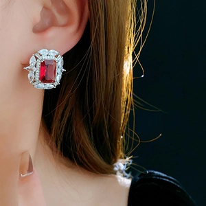 Gros plan de boucles d'oreilles en argent avec un grand zircon rectangulaire rouge