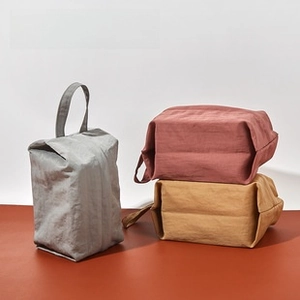 Three minimalist portable leather eyewear pouches in grey, pink and mustard yellow tones