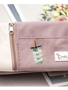 Detail of sword enamel pin with Fighting Invisible Battles text on canvas bag