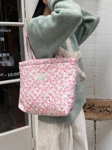 Detail of pink floral quilted cotton tote bag featuring diamond stitch texture and soft handles