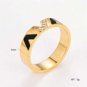Detail view of a 5mm wide gold ring with black enamel V pattern and crystal accents