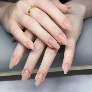 Macro shot of glossy almond-shaped nails with elegant nude pink gradient finish