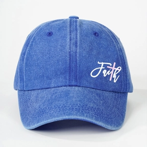 Close-up of the washed denim blue baseball cap with Faith embroidery and pink cross