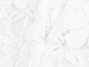 Détail d'une fermeture éclair invisible sur une robe en dentelle blanche à fleurs élégante