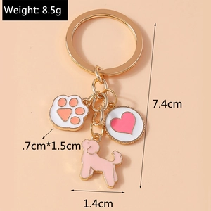 Detailed view of metal keychain with pink poodle, paw print and heart charms