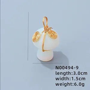 Détail d'un pendentif champignon en opale avec fil d'or torsadé montrant les dimensions