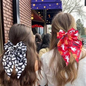 Detail of Halloween hair bows with ghost and pumpkin patterns on long streamers
