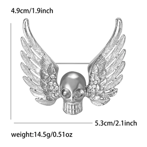 Detailed silver skull wing brooch with rhinestones showing dimensions of 4.9cm by 5.3cm