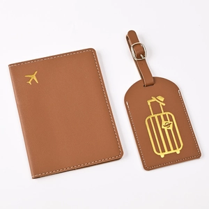 Close-up of brown PU leather passport holder and luggage tag with gold airplane embroidery