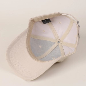 Inside view of beige cotton baseball cap featuring six-panel design and adjustable metal buckle