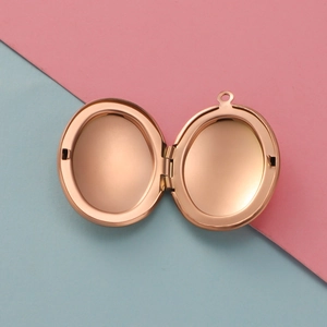 Detail view of open rose gold oval locket pendant showing the hinged internal structure