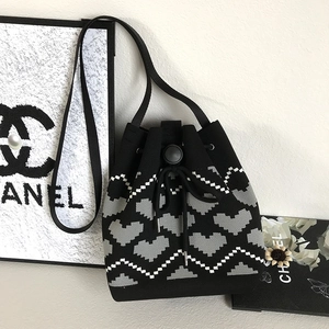 Detail view of the black and grey heart jacquard knit bucket bag with drawstring closure