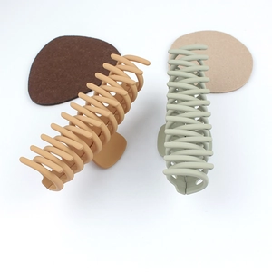 Oversized spiral claw clips in matte light brown and sage green for elegant hair styling