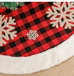 Detail of red and black buffalo plaid Christmas tree skirt with snowflake and faux fur edge