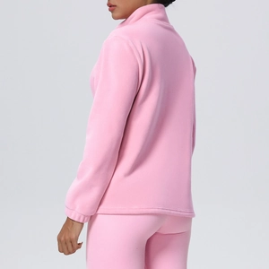 Detail view of pink fleece tracksuit featuring high collar and premium texture