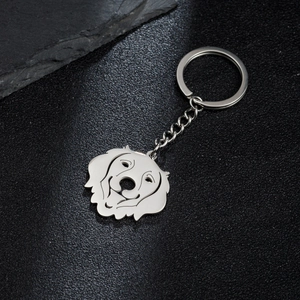 Polished stainless steel dog face outline keychain on dark stone background