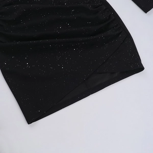 Detalle de tela negra brillante con destellos plateados y dobladillo asimétrico fruncido
