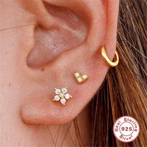 Golden 925 sterling silver snowflake earrings with sparkling zircon on model ear