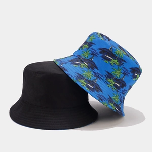 Detail of reversible bucket hat showing black solid color and blue tropical palm tree print