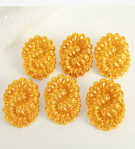 Detailed macro view of vintage gold twisted oval button earrings in titanium steel material