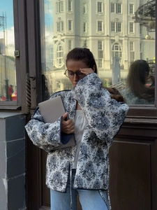 Close-up of vintage blue floral quilted jacket with tie-front detail and urban style