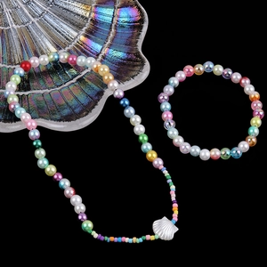 Colorful 6mm ABS pearl bead DIY jewelry set with a silver shell pendant on a black background