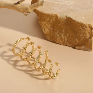 Detail view of 14K gold plated hoop earrings set with zircon on minimalist natural props