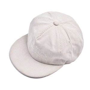 Detail of corduroy texture and white cursive embroidery on a flat brim baseball cap