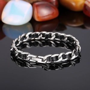 Bracelet gourmette avec incrustation de cuir tressé noir sur une surface réfléchissante