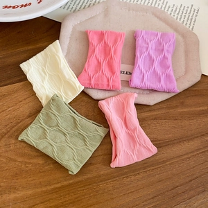 Detail showing five Morandi colors of wavy textured elastic fabric hair scrunchies on wood