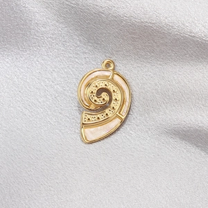 Close-up of golden nautilus shell pendant with white enamel on grey silk background