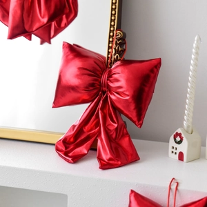 Glossy red Christmas bow ornament with metallic finish for festive tree decoration