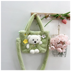 Detail of avocado green plush kids bag with 3D teddy bear and floral accents on a hook