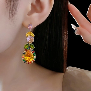 Macro detail of leaf and teardrop zircon earrings with vibrant multicolor gemstones