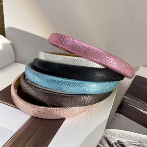 Close-up of glittery slim headbands in pink, silver, black, blue, and gold colors