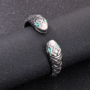 Vintage stainless steel open bangle featuring double snake heads with green gemstone eyes