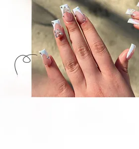 Detailed view of French tip press-on nails with pink base and butterfly rhinestone accents