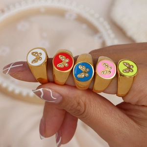 Detail of five 18K gold plated stainless steel rings with colorful enamel and crystal butterflies