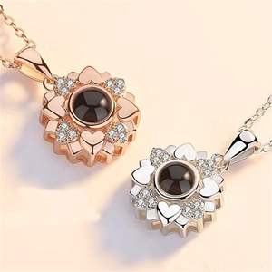 Close-up of sunflower pendant with 100 languages projection stone and pavé zircons
