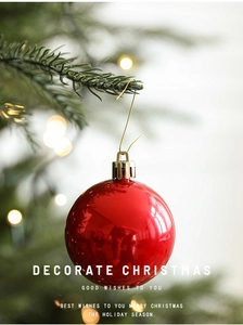 Close-up of bright red Christmas ball ornament hanging with S-shaped gold hook
