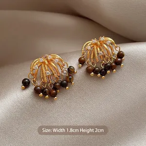 Detail shot of vintage tiger eye earrings with gold plating and white zircon inlay