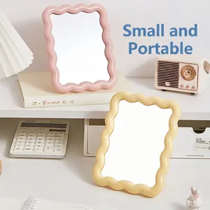 Pink and yellow wavy frame desktop makeup mirrors in a cozy aesthetic dorm setting