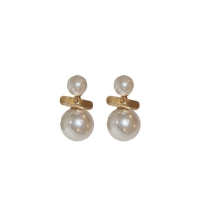 Elegant gold metal double pearl earrings featuring a vertical minimalist design on white back